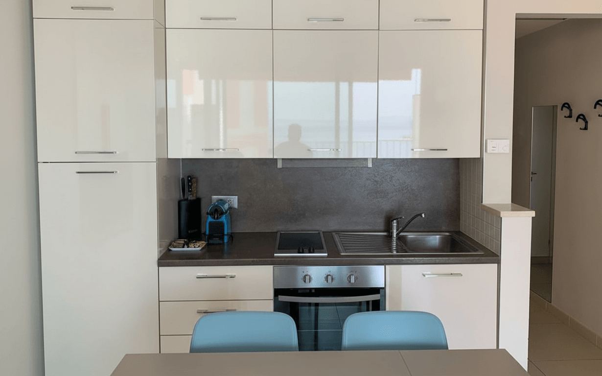 Equipped kitchenette with sink, stovetop and storage in the sea view studio