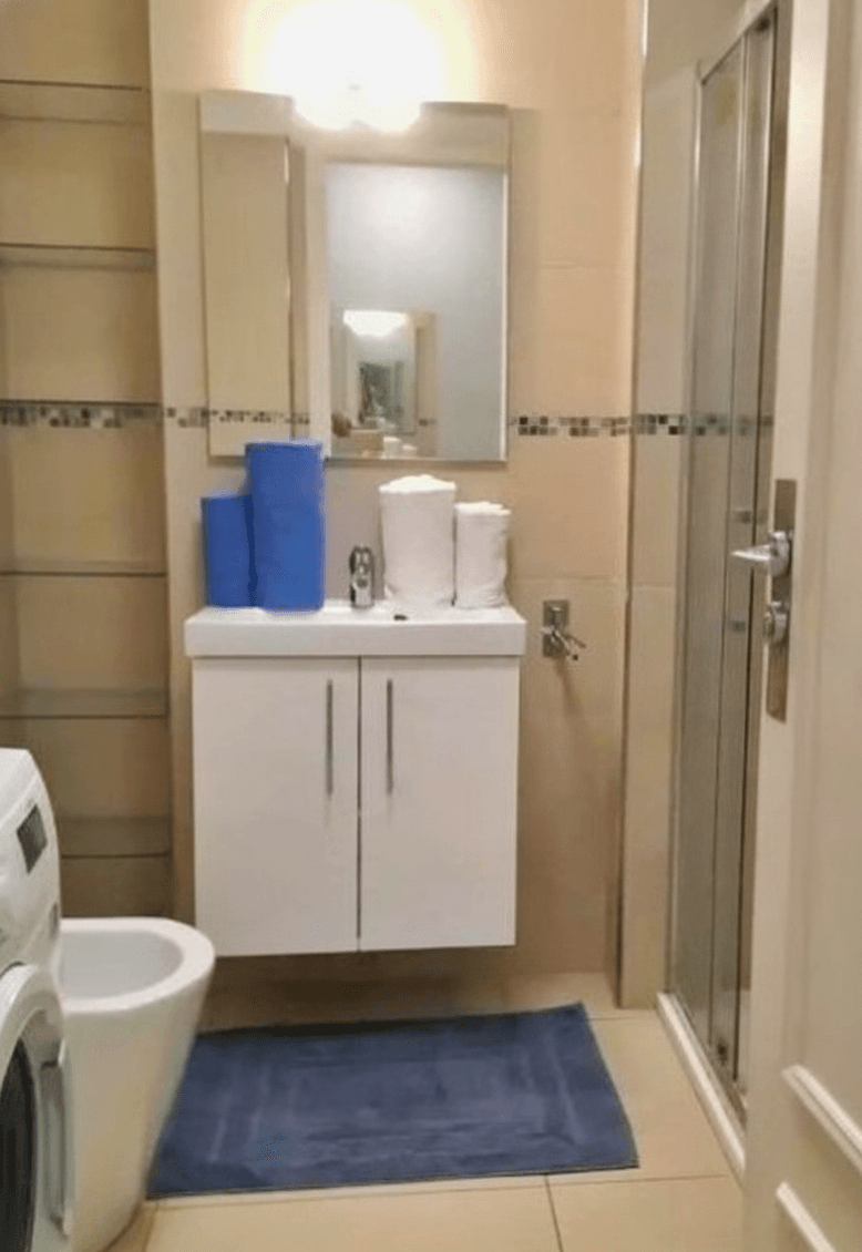 Private bathroom with sink, mirror and shower area